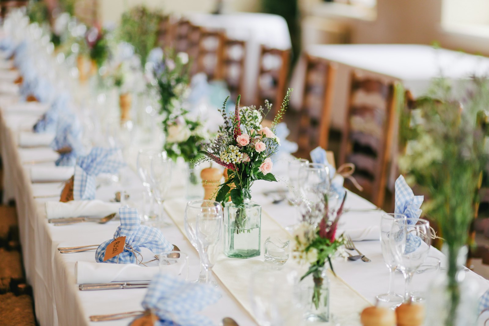 Long table set for an event, with flowers